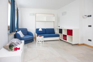 a living room with two blue chairs and a table at Casa Smith e Bice in Bormio