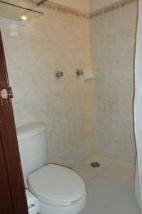 ein Badezimmer mit weißer Toilette und Dusche in der Unterkunft Hotel Fernando in Tuxtla Gutiérrez + 16 Fotos