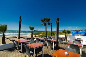 - un restaurant sur la plage avec des tables et des palmiers dans l'établissement Villa Las Chapas Playa, à Marbella