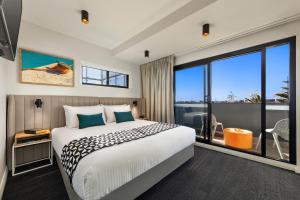 a bedroom with a large bed and a large window at Quest Fremantle in Fremantle