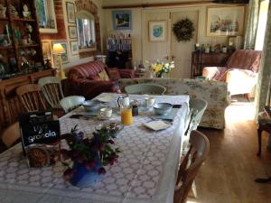 Garden Cottage B&b في Penton Mewsey: غرفة طعام مع طاولة مع الزهور عليها