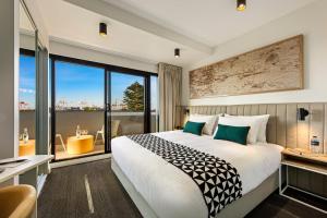 a hotel room with a bed and a large window at Quest Fremantle in Fremantle