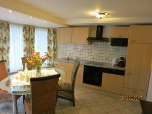 a kitchen with a table and chairs and a kitchen with a table and a table at Ferienwohnungen Kremsbrucker in Klagenfurt