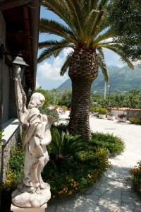 une statue d'un ange debout à côté d'un palmier dans l'établissement Residence Le Vigne, à Ischia