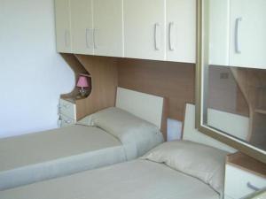 ヴィエステにあるVilla Graziaの白いキャビネット付きの小さな部屋のベッド2台