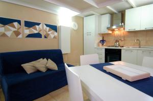 un soggiorno con divano blu e una cucina di Virna House a Castellammare del Golfo a Castellammare del Golfo