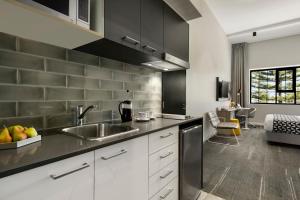 a kitchen with white cabinets and a sink at Quest Fremantle in Fremantle