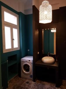 a bathroom with a sink and a washing machine at Lux Kolonaki Apartment in Athens