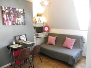 ベルク・シュル・メールにあるStudio Castillonのソファ、ピンクの枕とテーブルが備わる客室です。