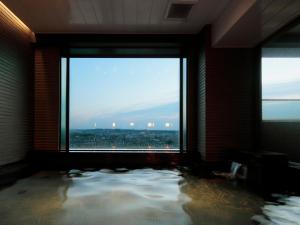 Zimmer mit einem großen Fenster und einem Pool mit Wasser in der Unterkunft Candeo Hotels Handa in Handa