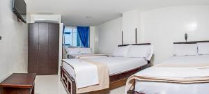 ブカラマンガにあるHotel Isla Mayorのベッド2台とテーブルが備わる客室です。