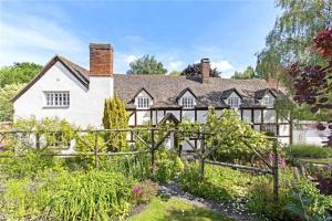 Una gran casa blanca con una valla en un jardín en Monkspool B&B, en Church End