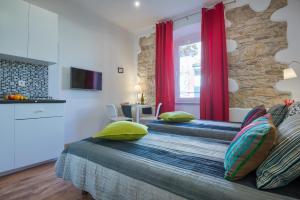 a bedroom with two beds and a window with red curtains at Top Center Rooms & Studio in Pula