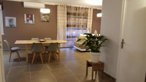 Le Gite de La Gravette في قرقشونة: غرفة طعام مع طاولة وكراسي وأريكة