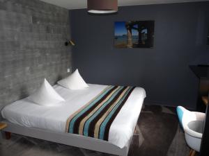 a bedroom with a bed with a striped blanket at Hôtel des Rochers in Perros-Guirec
