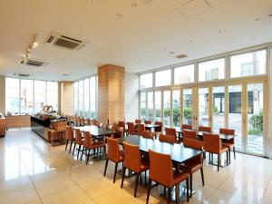 a conference room with tables and chairs and windows at Candeo Hotels Handa in Handa