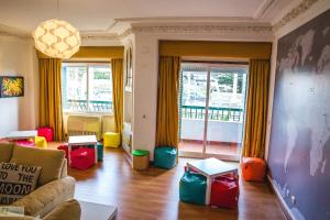 uma sala de estar com cadeiras coloridas e um sofá em Help Yourself Hostels - Carcavelos Coast em Carcavelos