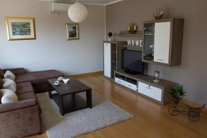 - un salon avec un canapé et une télévision dans l'établissement Sea Stone Apartment, à Podstrana