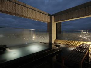 a bath tub on the roof of a building with a bench at Candeo Hotels Sano in Sano