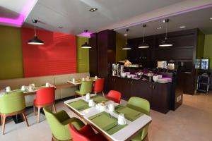 un restaurante con mesas y sillas coloridas y una barra en Hayat Heraa Hotel en Yeda