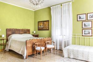 サン・フェリーチェ・デル・ベナーコにあるLa Villa del Lagoのベッドルーム1室(ベッド1台、椅子2脚、シャンデリア付)