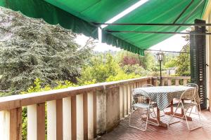 un patio con tavolo e sedie sul balcone. di La Villa del Lago a San Felice del Benaco