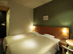 Postel nebo postele na pokoji v ubytování Candeo Hotels Sano