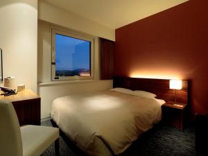 A bed or beds in a room at Candeo Hotels Ozu Kumamoto Airport