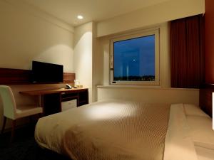 Candeo Hotels Ozu Kumamoto Airport tesisinde bir odada yatak veya yataklar