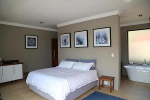 a bedroom with a bed and a sink and a tub at Natures Haven in Roodepoort