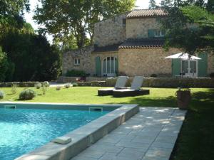 een huis met een zwembad voor een tuin bij Mas de l'ile in Avignon