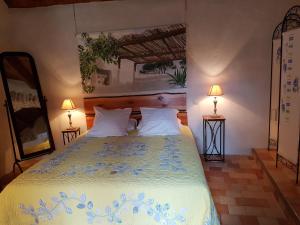 a bedroom with a large bed with two lamps at La Terrasse de Peyre in Comprégnac +16 photos