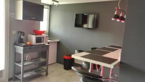 a small kitchen with a table and a microwave at Au Studi'Ô in Saint-Bonnet-en-Champsaur