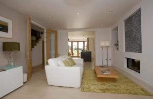 a living room with a white couch and a fireplace at Waterford Castle Hotel Lodges in Waterford