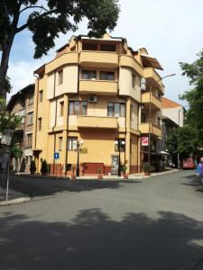 un edificio amarillo al lado de una calle en Hristovi Apartments & Studios, en Pomorie