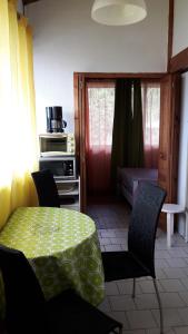 Un comedor con mesa y sillas y una cocina. en Studios La Gemme, en Dax