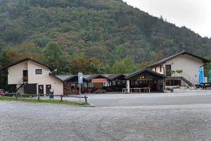 a building on the side of a road with a mountain at Rooms Tolminska korita in Tolmin