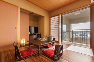 una sala da pranzo con tavolo e sedie e un balcone di Hotel East China Sea a Isola di Ishigaki