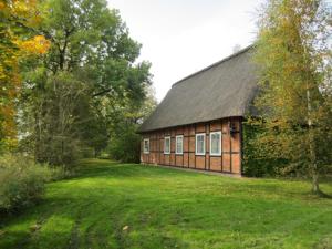 ein Gebäude mit einem Rasenplatz davor in der Unterkunft Gästehaus Eulennest in Großenwörden