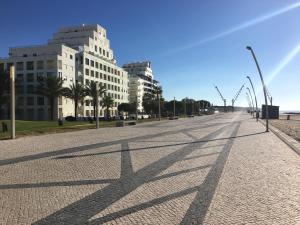 an empty street with buildings and shadows on the ground at Apartamento Praia Da Gaivota in Quarteira