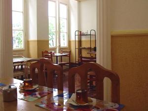 a dining room with a table and chairs and windows at Palace Hotel in Curitiba