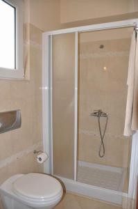 uma casa de banho com um chuveiro, um WC e um lavatório. em Beautiful house with garden in Rhodes em Ialyssos