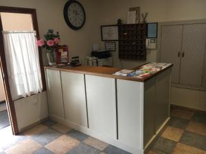 an office with a counter and a clock on the wall at Hostal El Pinar in Avila