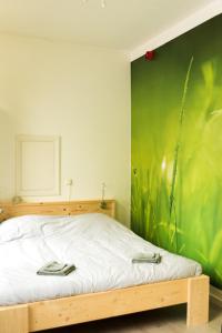 a bedroom with a bed with a green wall at Studio RoSa in Nijmegen