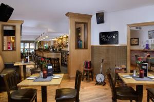 a restaurant with tables and chairs and a bar at Coachmans Townhouse Hotel in Kenmare