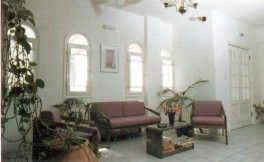 a living room with purple furniture and a christmas tree at Silver Rocks Hotel in Chrissi Akti
