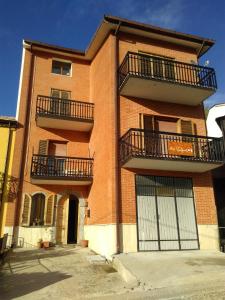 a red brick building with two balconies and two gates at B&B Tufaro Alberico in Terranova di Pollino