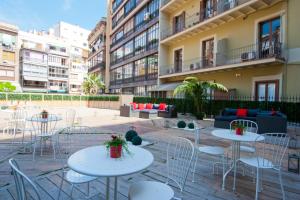 un patio con mesas y sillas frente a un edificio en BacHome Terrace B&B, en Barcelona