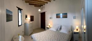 a white bedroom with a bed and two lamps at Masseria La Torre in Maglie
