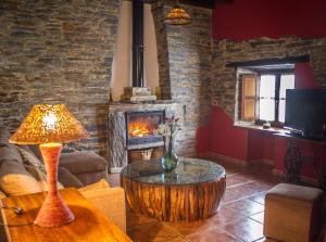a living room with a table and a fireplace at Apartamentos Rurales El Foro in Andés